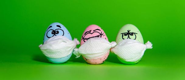 Divertenti tre uova in una maschera per Pasqua isolate su uno sfondo verde - Foto, immagini