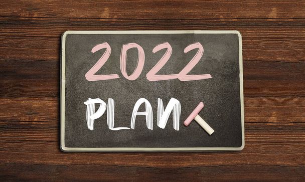 Plan 2022 escrito en pizarra sobre tabla de madera. Motivación empresarial inspiración desafío concepto e idea de éxito - Foto, Imagen
