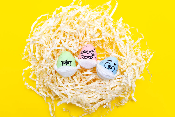 Ovos engraçados com olhos, mascarados para a Páscoa. Ninho com três ovos engraçados - Foto, Imagem
