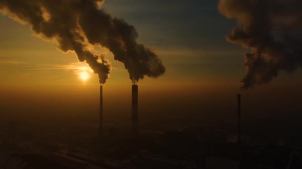 Erőmű-kibocsátás a város felett napkeltekor. Környezetszennyezés. Gyári cső szennyező levegő.Panoráma naplemente. Dohányzó csövek Légi kilátás, - Felvétel, videó
