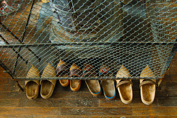 Nederlandse houten schoenen staan bij een kachel - Foto, afbeelding