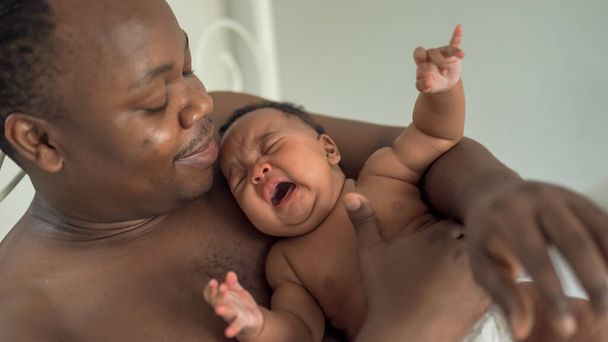 幸せなアフリカ人男性と彼の小さな赤ちゃん - 写真・画像