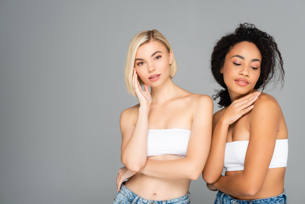 Young interracial women with perfect skin posing isolated on grey  - Foto, imagen