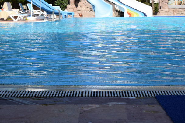 Uima-allas matkailukohteessa kesäaikaan. Aqua Park vesiliukumäkiä ja suuri uima-allas. Hotellin rentoutumis- ja auringonottoalue - Valokuva, kuva