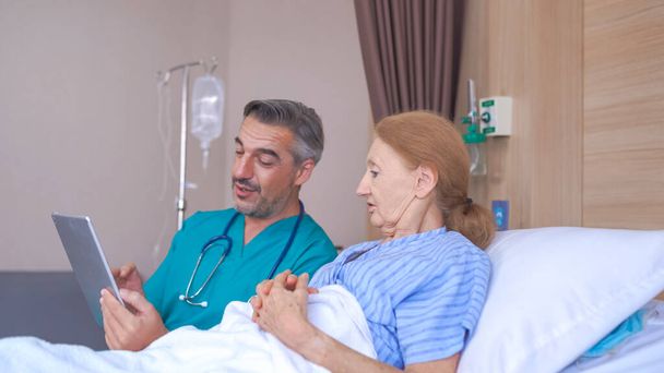 Doutor conversando com paciente sênior com tablet na cama do hospital - Foto, Imagem