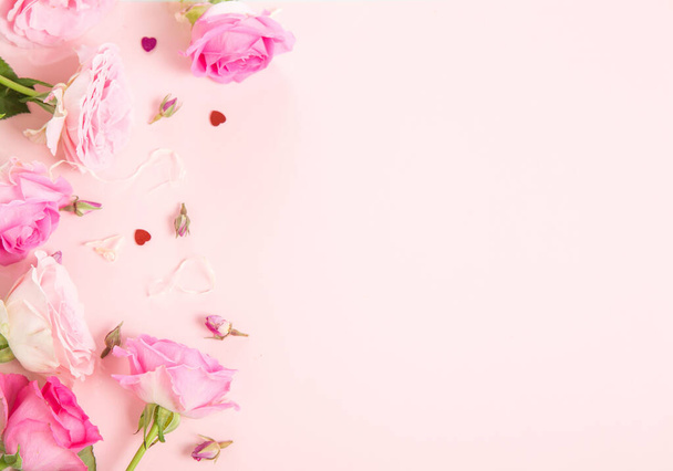 Zusammensetzung der Blumen. Rahmen aus rosa Rosenblüten auf rosa Hintergrund. Flache Lage, Draufsicht, Kopierraum - Foto, Bild
