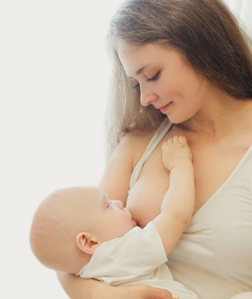 Portrait close up of happy young mother breastfeeding her baby at home - Foto, Imagem