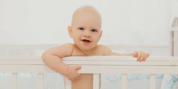 Portrait of cute baby sitting in the bed at home - Foto, imagen