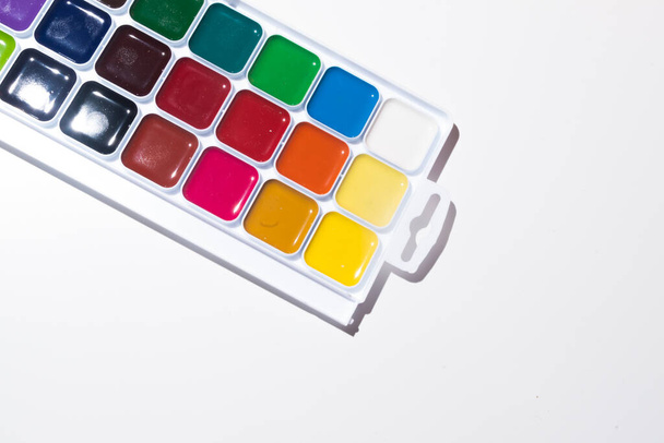 Top view of set of watercolor paints  in a box, isolated on white. Back to school concept. Concept for a painting school or art store. Hobby concept for children and adults. Minimalism, top view, copy space. - Foto, Imagem