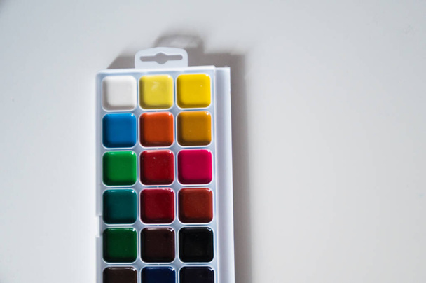 Top view of set of watercolor paints  in a box, isolated on white. Back to school concept. Concept for a painting school or art store. Hobby concept for children and adults. Minimalism, top view, copy space. - Fotografie, Obrázek