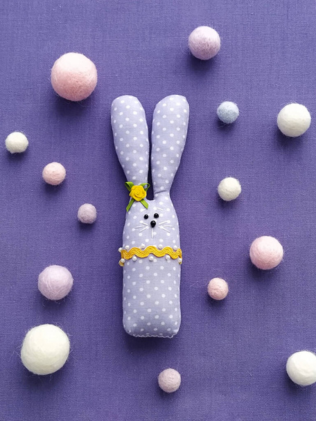 Tkanina zabawki Bunny na fioletowy bawełniany obrus świętować Wielkanoc i pastelowe wełniane kulki, DIY, płaski leżak - Zdjęcie, obraz