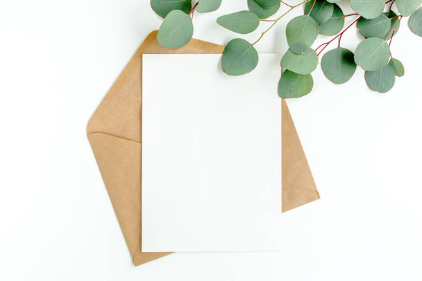 Mockup invitation, blank greeting card and green leaves eucalyptus. Flat lay, top view. - Foto, Imagem