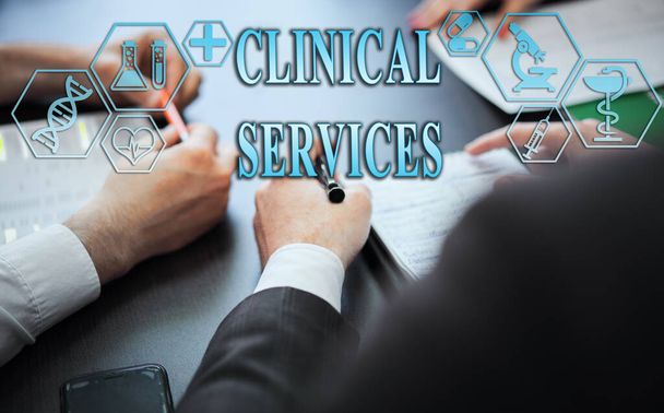 Medical healthcare concept - group of doctors in hospital with digital medical icons, graphic banner showing symbol of medicine, providing medical care. The inscription "CLINICAL SERVICES" - Фото, изображение