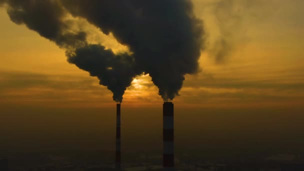 Air pollution. clouds of smoke coming from the chimneys of the plant with beautiful golden yellow lighting of setting sun. Drone flying over smoking smokestacks of a steel factory. - Footage, Video