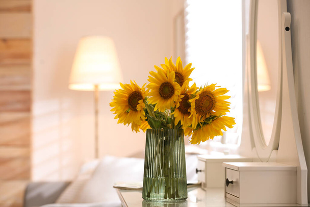 Beautiful bouquet of sunflowers in vase on white table indoors. Space for text - Foto, immagini