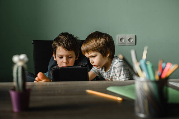 子供たちは家でタブレットをプレイし、技術で成長します。 - 写真・画像
