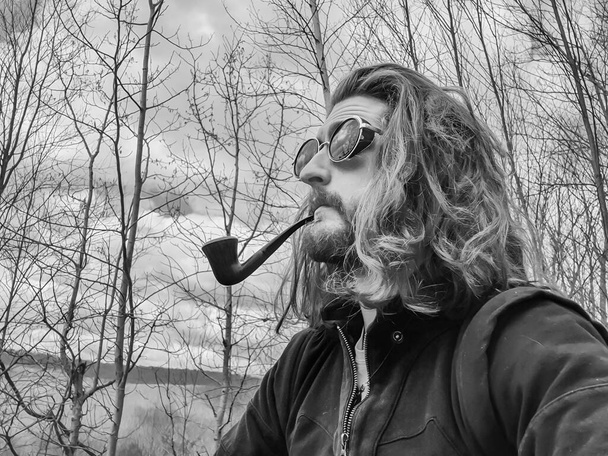 Junger Mann im Hipster-Stil raucht eine Vintage-Pfeife - Foto, Bild