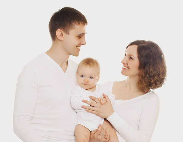 Family portrait of happy smiling mother, father looking at each other and their cute baby over a white background - Foto, Bild