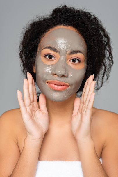 African american woman with clay mask looking at camera isolated on grey  - Photo, Image