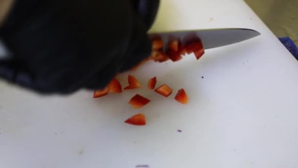 Groenten snijden met een metalen mes op een witte snijplank. Koken in de keuken. - Video