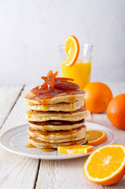 オレンジマーマレードとパンケーキタワー,素朴な木製のテーブルの上で朝食のための新鮮なオレンジとジュース - 写真・画像