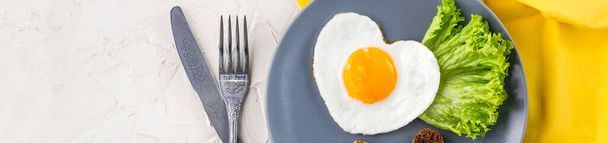 banner of Valentines day breakfast with heart shaped fried eggs served on grey plate and yellow napkin. flat lay, top view - Photo, Image