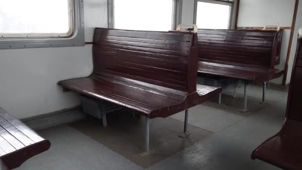 Fila di vecchi sedili vuoti in legno marrone in un treno retrò guida. - Filmati, video