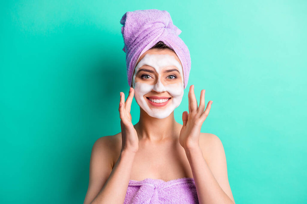 Photo of pretty relaxed young lady foam mask palms face wear purple towel turban isolated turquoise color background - 写真・画像