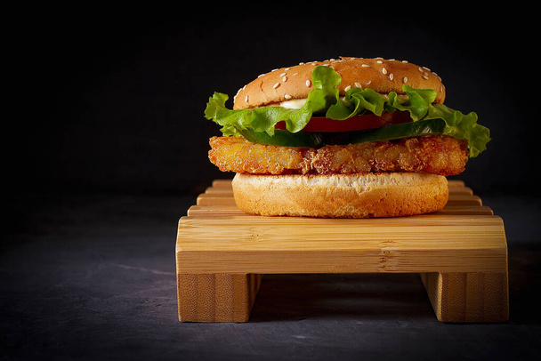 Vegan burger, on a wooden stand, black background, horizontal, no people, - Photo, Image