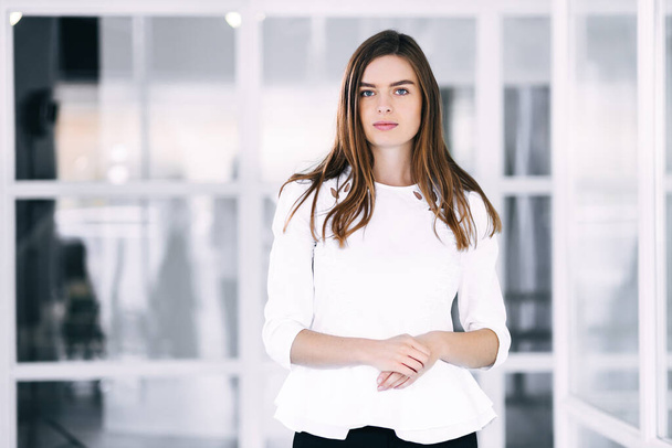 Beautiful smiling businesswoman standing with arms crossed at workplace. - Fotoğraf, Görsel