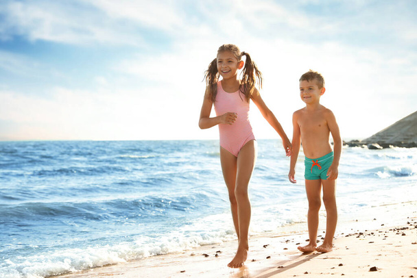 Cute children enjoying sunny day at beach. Summer camp - Foto, afbeelding