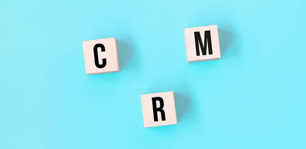 Concept word CRM business to business on cubes on a beautiful blue background. Business concept. Copy space. - Φωτογραφία, εικόνα