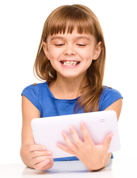 Young cheerful girl is using tablet - Foto, Imagen