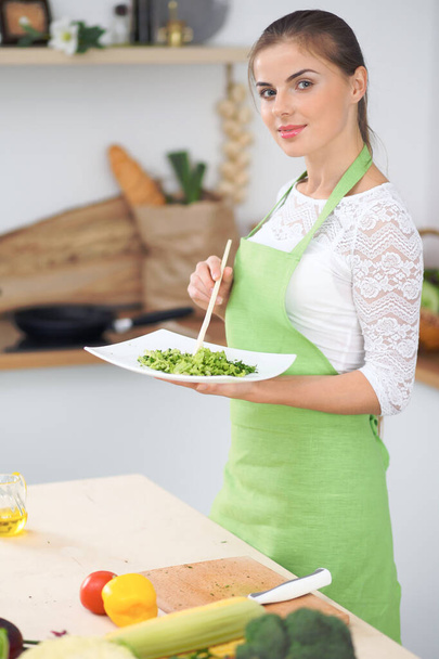 Young woman housewife cooking in the kitchen. Concept of fresh and healthy meal at home - Foto, immagini
