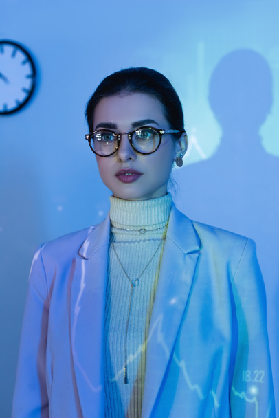 businesswoman in glasses and suit looking away in office - Фото, зображення