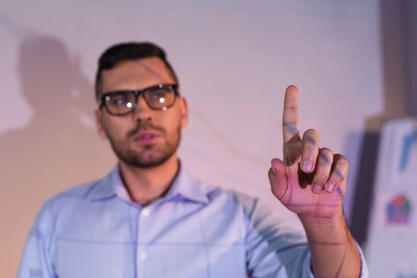 blurred businessman in glasses pointing with finger in office - Foto, Bild