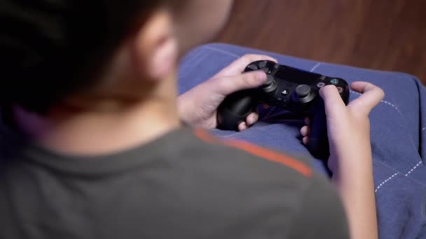 十代の男の子はジョイスティックでビデオゲームをプレイし、指でボタンを押す。4K - 映像、動画