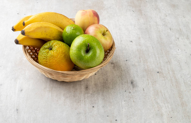 Frutas em uma cesta sobre mesa com espaço de cópia. - Foto, Imagem