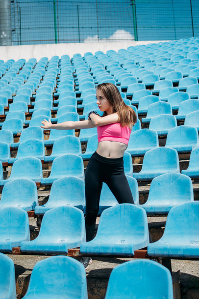 Teen Fitness, Physical activity for teenagers. Young sporty girl having workout, running, doing exercises on the stadium - Photo, Image
