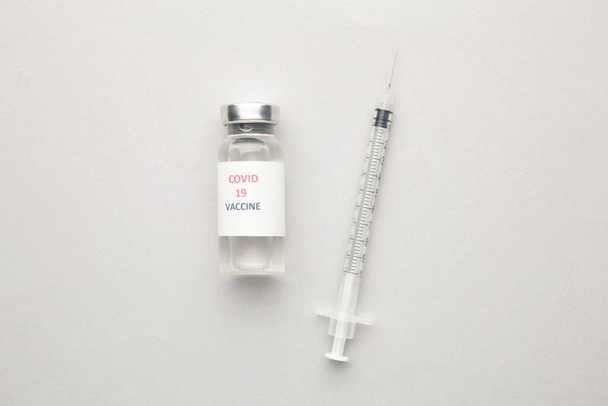 Coronavirus COVID-19 rokotepullot ja ruisku harmaalla pohjalla. Yläkuva - Valokuva, kuva