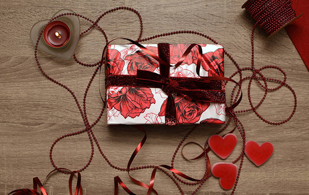 Biały list, świeca, pudełko prezentów i cukierki w kształcie serca. Prezent dla kochanków - Zdjęcie, obraz