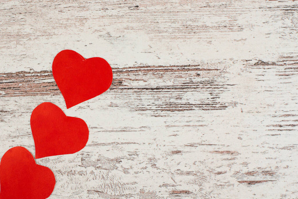 few red Love hearts on white-painted wooden texture background with  copyspace - Foto, Imagem