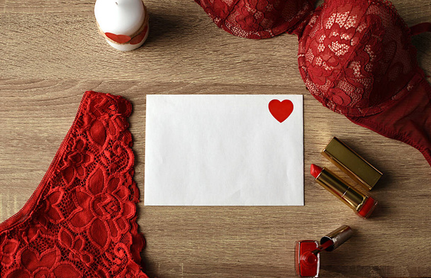 Punainen kynsilakka, huulipuna ja alusvaatteet valkoinen sydän kääreet. päivämäärän valmistelu - Valokuva, kuva
