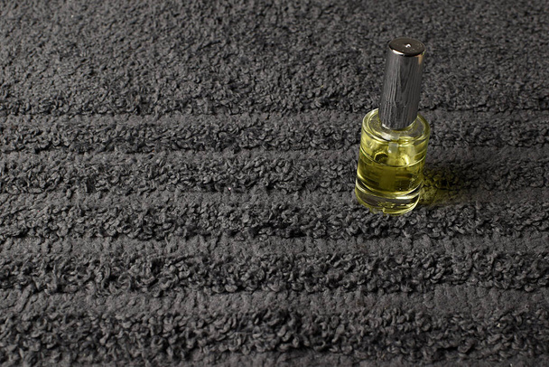 Uma garrafa de óleo sobre um fundo de toalha cinza. Spa em casa, segurança - Foto, Imagem