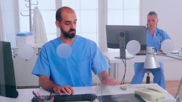 Ιατρικοί ρεσεψιονίστ που εργάζονται σε νοσοκομειακή κλινική απαντώντας στο τηλέφωνο - Πλάνα, βίντεο