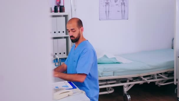 Homme médecin de santé répondant aux appels téléphoniques travaillant à l'hôpital - Séquence, vidéo