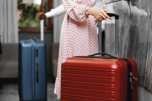 Unrecognizable man and woman with suitcases standing near reception in hotel - Foto, Imagem