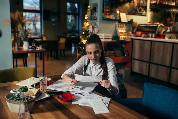 woman entrepreneur dealing with financial in her restaurant - Фото, зображення