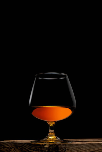 un bicchiere di whisky con scatola di legno su sfondo nero - Foto, immagini