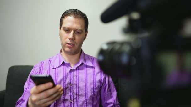 Hombre haciendo video blog sobre teléfonos móviles. - Metraje, vídeo